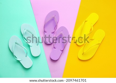 Set of stylish flip-flops on color background Royalty-Free Stock Photo #2097461701