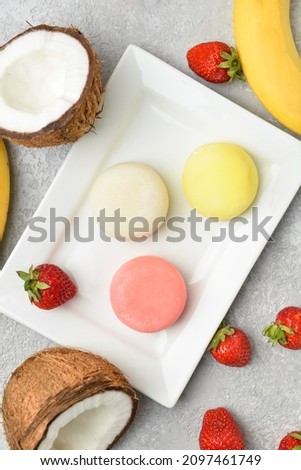 Plate with tasty Japanese mochi and fruits on light background, closeup