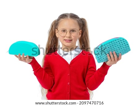 Little girl with pencil cases on white background