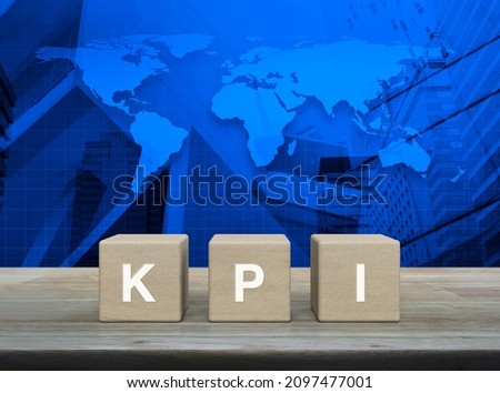 KPI acronym on block cubes on wooden table over world map, modern city tower and skyscraper, Key Performance Indicator business target concept, Elements of this image furnished by NASA