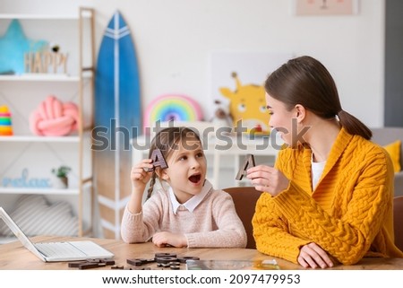 Speech therapist working with cute girl in clinic Royalty-Free Stock Photo #2097479953