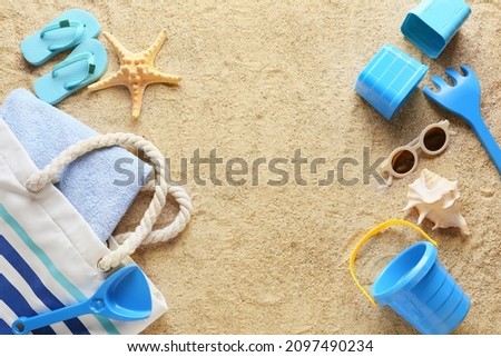 Set of beach accessories for children, bag and towel on sand Royalty-Free Stock Photo #2097490234