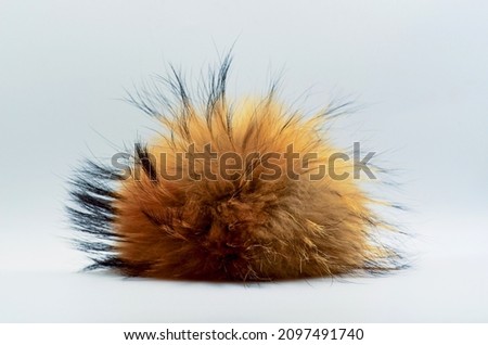 Fluffy lump, fluff in the center of the frame, fur toy, fluffy red fur, place for text, unusual background, piece of fur, fox fur  Royalty-Free Stock Photo #2097491740