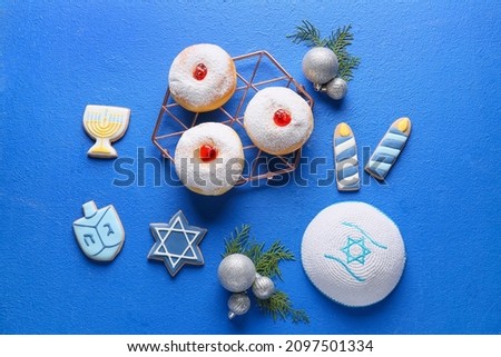 Symbols of Hanukkah with Christmas decor on color background