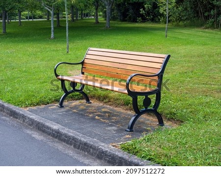 Wooden bench with black metal iron cast frame in park