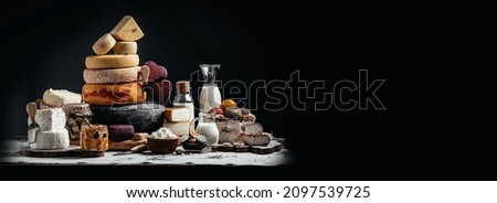 large assortment of international cheese Petit Basque, French cheese board of various types of soft and hard cheese. spanish manchego cheese on black background, Long banner format Royalty-Free Stock Photo #2097539725