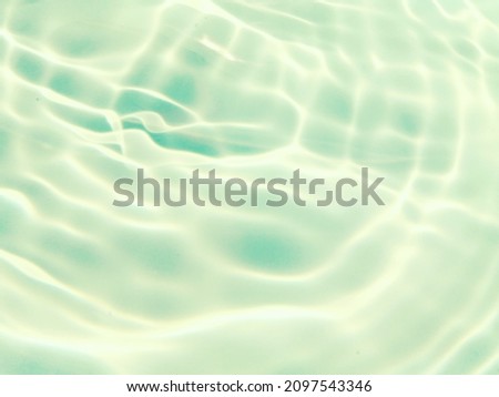 Closeup​ blur​ abstract​ of​ surface​ blue​ water. Abstract​ of​ surface​ blue​ water​ reflected​ with​ sunlight​ for​ background.Top​ view​ of blue​ water.​ Water​ splashed​ use​ for​ background.