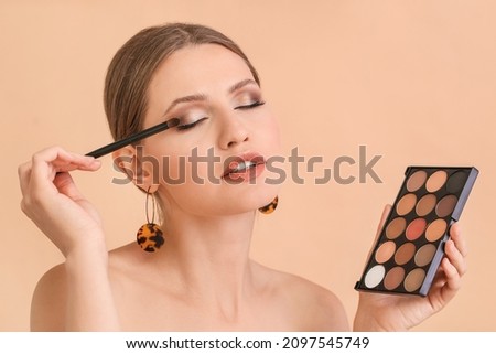 Young woman with beautiful eyeshadows on color background Royalty-Free Stock Photo #2097545749
