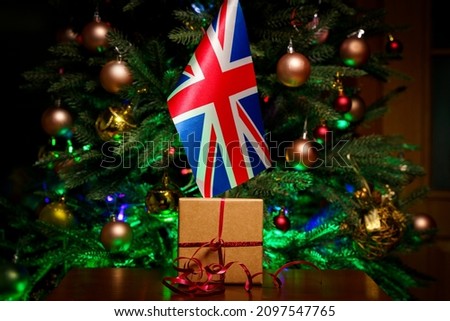 Great Britain flag and gift box on the background of the Christmas tree