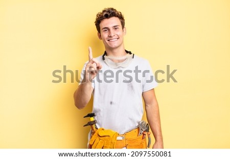 smiling proudly and confidently making number one pose triumphantly, feeling like a leader. handyman concept