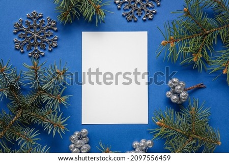 Blank card with fir branches and Christmas decor on blue background