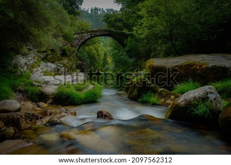 A beautiful scene with a bridge over the peaceful river in Geres National Park, Portugal