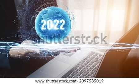 Businessman hand holding 2022 number,happy new year concept digital trends,industry and business trend of world full modernity advanced technology,artificial intelligence or AI.