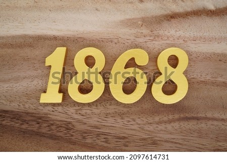 Golden Arabic numerals 1868 on a dark brown to white wood grain background.