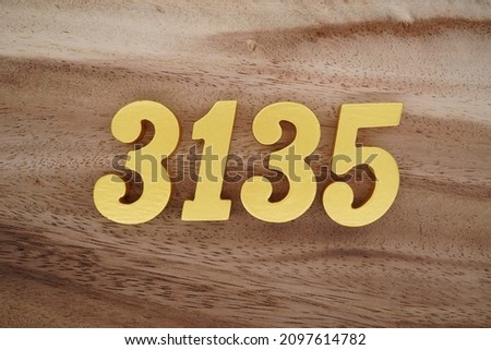 Golden Arabic numerals 3135 on a dark brown to white wood grain background.