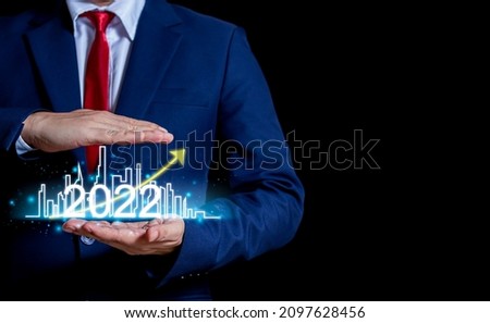 Businessman presenting growth process 2022 stocks finance communication and business select city house real estate city concept and home icon business concept technology internet and network. 
