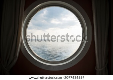 View of the sea from a round ship window Royalty-Free Stock Photo #2097636559