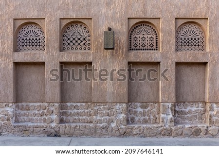 Arabic style window portals in stone wall with ornaments, traditional arabic architecture, Al Fahidi, Dubai, United Arab Emirates. Royalty-Free Stock Photo #2097646141