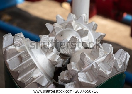 A polycrystalline carbide drill bit, using for drill a subsurface rock structure in oil drilling operation. Oil industrial heavy equipment object photo. Close-up and selective focus. Royalty-Free Stock Photo #2097668716