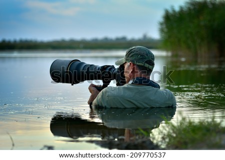 wildlife photographer outdoor, standing in the water Royalty-Free Stock Photo #209770537