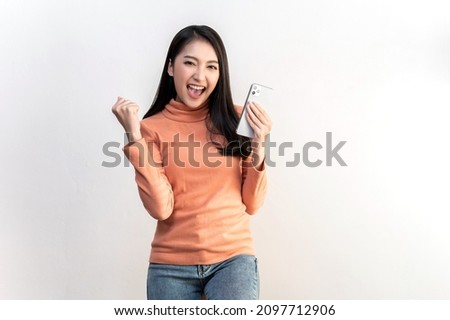 Portrait photo of young beautiful Asian woman feeling happy or surprise shock and holding smart phone on white background can use for advertising or product presenting concept. Royalty-Free Stock Photo #2097712906