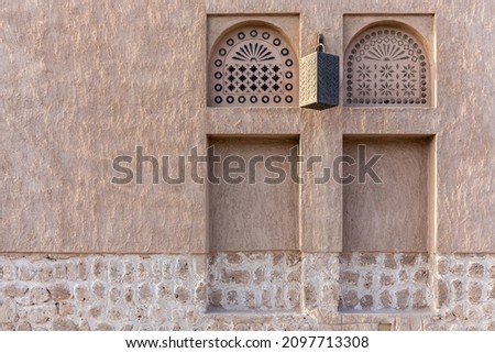 Arabic style window portals in stone wall with ornaments, traditional arabic architecture, Al Fahidi, Dubai, United Arab Emirates, copy space. Royalty-Free Stock Photo #2097713308
