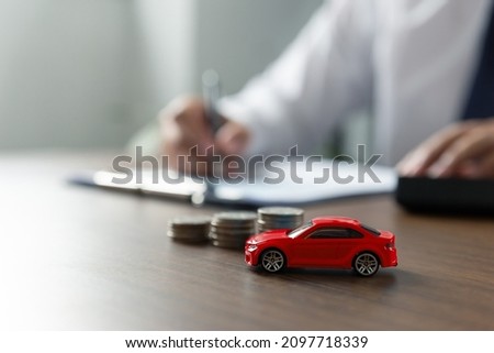 Young man is signing a car loan contract, car trading at workshop, car finance and insurance concept.