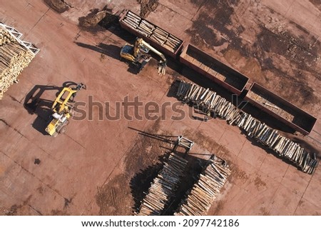 Excavator with log grab crane unloads timber from freight car. Out of focus, possible granularity.
 Royalty-Free Stock Photo #2097742186