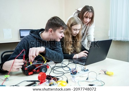 Diverse teenager pupils build robot vehicle learning at table at STEM. Classroom with pupils learning programming language and software design using laptop compute Royalty-Free Stock Photo #2097748072