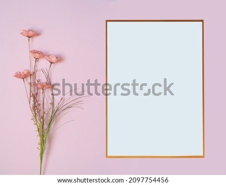 White frame blank and pink flowers composition on pink background. Flat lay, top view.Copy space.Greeting card for mother's day, women's day, valentine's day, happy birthday, wedding.