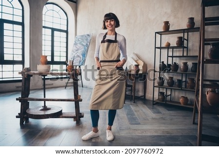 Full length photo of confident successful small business owner lady potter stand in her artwork exhibition museum workroom