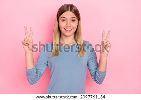 Photo of youth cheerful pretty girl show fingers peace cool v-symbol isolated over pink color background