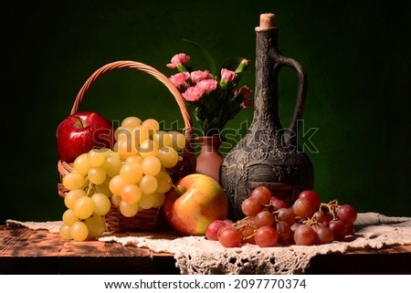 Picture with wine in the background. Still life with fresh fruits such as red and white grapes, tangerines, clementines and lime with a bouquet of cloves. a perfect composition as a background for a d