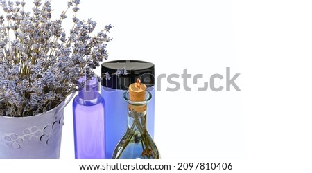 Body care products with lavender; oil, cream and dried lavender flowers isolated on a white background.Wide photo. Free space for text.