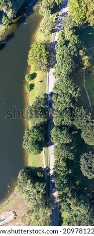 An aerial shot over a residential neighborhood in Florida with a golf course, the trees casting shadows on a sunny day, grass field that needs watering, by green pond.