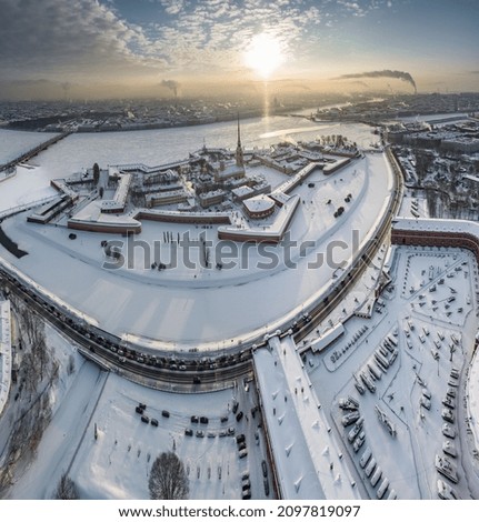 Drone point of view of winter St. Petersburg at sunset, frozen Neva river, steam over city, Peter and Paul fortress, car traffic on Trinity bridge, rostral columns, Palace drawbridge, panoramic view