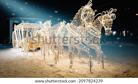 an image of a horse carriage and a carriage made of Christmas lights. new Year's decoration in the park.