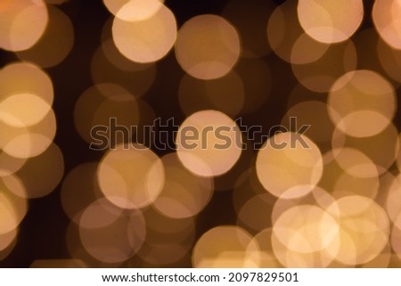 Christmas and Happy new year blurred background with bokeh abstract lights in golden tones