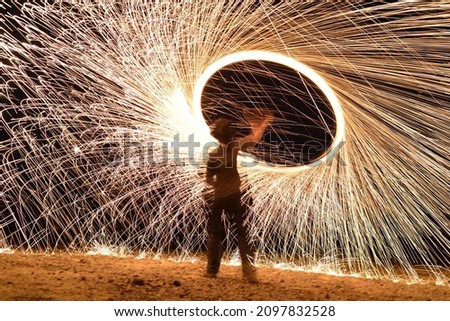 Iron wool circle drawing light fireworks. Burning Steel Wool spinning, Trajectories of burning sparks at night. Movement light effect, steel wool fire hoop. long exposure light painting, Pyrotechnic Royalty-Free Stock Photo #2097832528