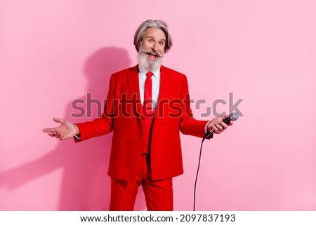 Portrait of attractive cheerful grey-haired man mc mr mister showman holding mic isolated over pink pastel color background