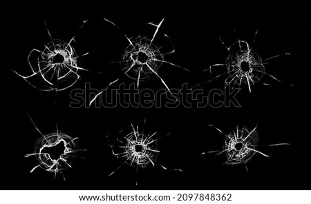 Collage of cracks in the glass, a hole from bullets in the glass on a black background. Window glass texture.