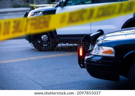 Detail view of illuminated police lights and cordon tape. Royalty-Free Stock Photo #2097855037