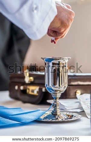 
rabbi dipping gauze in wine for brit mila Royalty-Free Stock Photo #2097869275