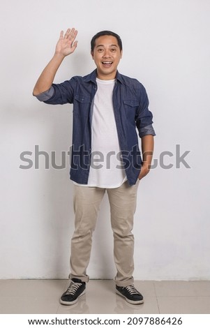 Full body portrait of casual asian man with say Hi gesture and smiling to camera isolated on white background Royalty-Free Stock Photo #2097886426