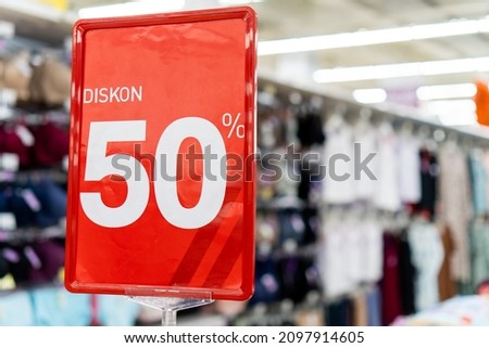 Promotion of 50% discount on clothing prices at the mall with a red banner background