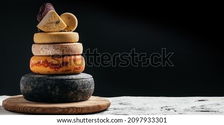 variation of hard and semi-hard cheese on dark background. Petit Basque, French cheese, spanish manchego cheese. Royalty-Free Stock Photo #2097933301