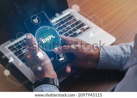 Businessmen holding a smartphone with icons of  BNPL with online shopping icons technology. BNPL Buy now pay later online shopping concept. Royalty-Free Stock Photo #2097945115