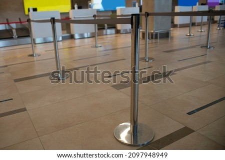 Fence rack with pulling tape at the airport. Barrier racks to delimit passengers in line. Royalty-Free Stock Photo #2097948949