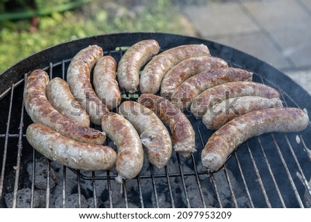 Barbecue grill bbq on coal charcoal grill with raw bratwurst sausages meat delicious summer meal