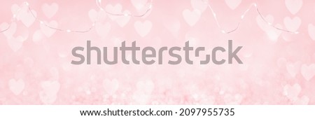 Abstract red pink heart glitter light bokeh holiday and festive party background. Tender wire lights string on top. Love sentiment and St Valentine's day concept backdrop banner with copy space